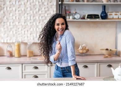 Fun At Home Alone. Happy Woman Singing At Appliance As Imaginary Microphone, Dancing In Kitchen Interior, Copy Space. Lady Enjoying Free Time