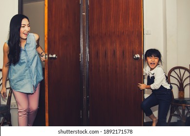 Fun In The House: Mom And Daughter Play Peekaboo Games Together In The Bedroom Behind The Door And Have Fun Hiding.