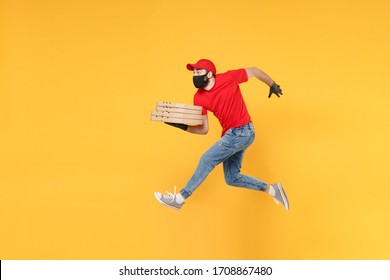 Fun jumping delivery man in red cap t-shirt uniform sterile face mask gloves isolated on yellow background studio Guy employee courier Service quarantine pandemic coronavirus virus 2019-ncov concept
