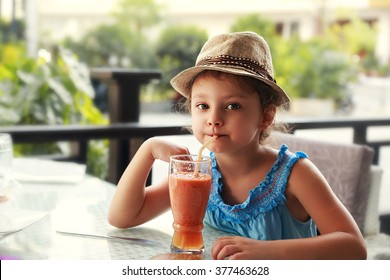 Fun Kid Girl In Fashion Hat Drinking Smoothie Juice In Street Restaurant 