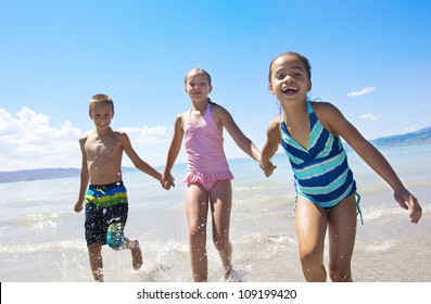 Fun Kids Playing At The Beach