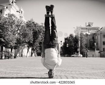 Fun Man Dancing. Clothed T-shirt, Jeans, Slim Sport Body. Motion On Great Urban City. Amazing Portrait. Sports Acrobatic Handstand. Fitness Concept. Cool Jump. Head Over Heels. Black And White Quest