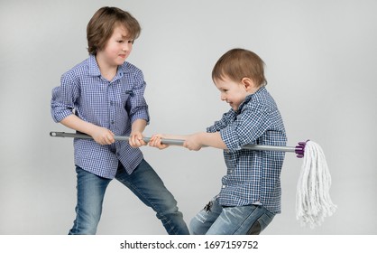 Fun Noisy Game Of Two Brothers - Dragging A Mop From Hand To Hand. Happy Childhood, Noisy Brawl, Shooting Children In The Studio, Family Life, Older Brother, Younger Brother, Conflict Resolution