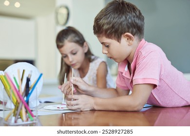 Fun, painting and kids at table together for growth, creative development or homeschool for sibling bonding. Art, craft and children drawing with watercolor, brush and teamwork project in living room - Powered by Shutterstock