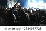 Lot fun people record music video use mobile phone. Fan crowd shoot k pop live concert. Many men hang out cool rave fest. Joy group chill night club hall. Dj star raise hand up. Make light glow photo.