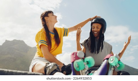 Fun, playful and interracial couple rollerskating at a park, helping with helmet and gear in Brazil. Happy, laughing and man and woman getting ready to skate while bonding, talking and active