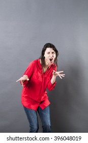 Fun Shouting Concept - Wild Young Woman Shouting And Dancing With Weird Body Language And Hand Gesture To Express Excitement On Grey Background.