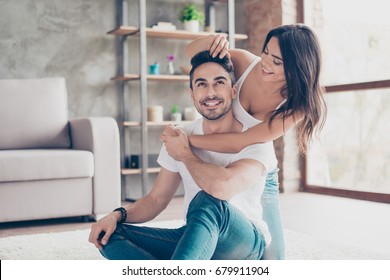 Fun together. Happy beautiful married latino couple is chilling out on the carpet at the floor at home indoors, enjoying and smiling