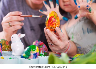 fun while painting Easter eggs. Family egg decoration as a tradition for Easter holiday. Close up for egg and hands of little girl.
