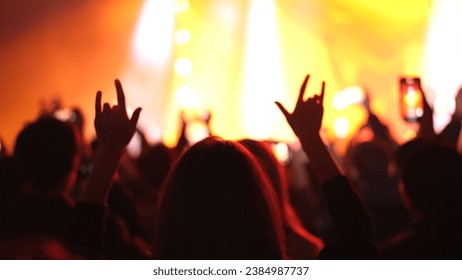 Fun woman show rock n roll gesture. Heavy metal hand up sign. Hip hop live music concert. Cool people hang out dance party. Joy fan chill open air rave fest. Girl enjoy epic disco song Night club life - Powered by Shutterstock