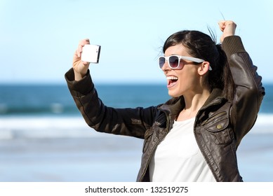 Fun Woman Video Call On Cellphone. Playful Happy Girl On Vacations Taking Self Photo On Sea Background At The Beach.