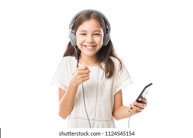 Fun young child enjoying rhythms in listening to music on headphones - Powered by Shutterstock