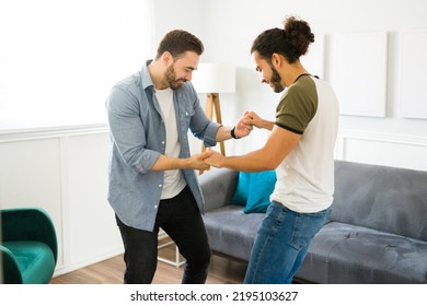 Fun Young Gay Couple Dancing Together While Listening To Dance Music In The Living Room