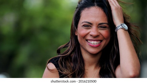 Fun Young Hispanic Woman Laughing With Friend In Conversation Outside