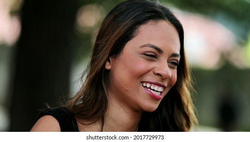 Fun Young Hispanic Woman Laughing With Friend In Conversation Outside