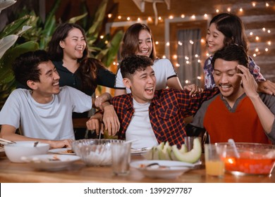 Fun Young People Laughing While Having Garden Party At Home And Having Some Dinner