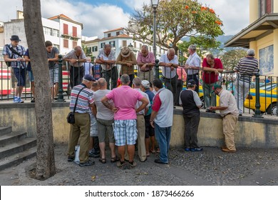 Funchal At Madeira, Portugal - August 01, 2014: Group Of Older Men Looking To Two Man Playing Cards