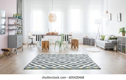 Functional apartment with dining table, sofa and pattern rug - Shutterstock ID 605420468