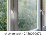 Functional PVC windows with durable frame, resistant to weather conditions, effectively mute noise, heat-absorbing and energy efficient. Modern apartment solutions, selective focus on handle