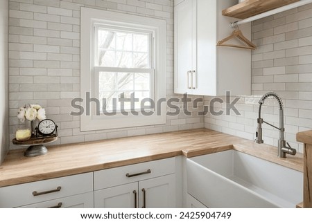 Functional and Stylish Laundry Room with Custom Cabinets and Countertop. Social Media and Copy Space. Wooden Countertops with Neutral Beige Subway Tile.