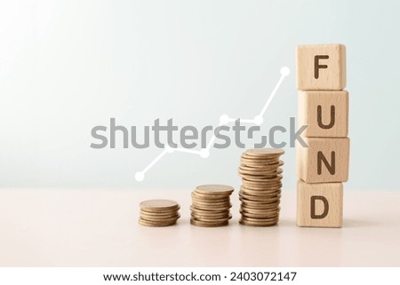 FUND text on wooden cube block with stack of coins above and graph line for business investment , strategy concept