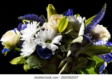 Funeral Bouquet purple White flowers, Sympathy and Condolence Concept on blackbackground with copy space.