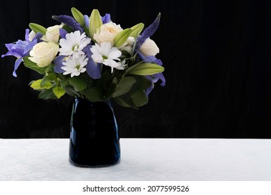 Funeral Bouquet Purple White Flowers, Sympathy And Condolence Concept On Blackbackground With Copy Space.