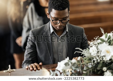 Funeral coffin, death and black man sad, grieving and mourning loss of family, friends or dead loved one. Church service, floral flowers and person with casket, grief and sadness over loss of life