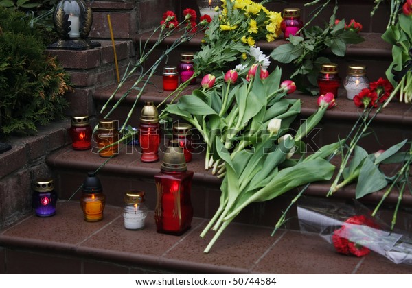Funeral flowers and\
candles on the stairs