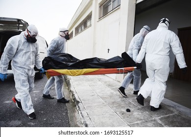 Funeral Home employees wear protective suits to protect themselves from Coronavirus, as they carry a dead body inside Bag. - Shutterstock ID 1693125517