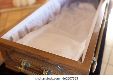Funeral And Mourning Concept - Close Up Of Open Empty Coffin In Church