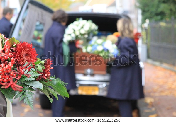 Funeral procession with\
flowers in car