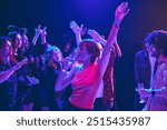 Fun-filled Halloween party with young adults in costumes ranging from witches to monsters, enjoying treats, and dances. Dimly lit nightclub. Concept of Halloween, holiday, party, leisure