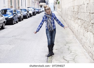 A Funky Cool Edgy Teenager Wandering The Streets, Balancing On The Sidewalk