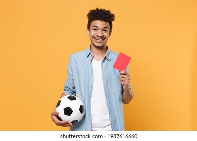 Funny African American Guy Football Fan Player In Blue Shirt Isolated On Yellow Background. Sport Leisure Concept. Cheer Up Support Favorite Team Soccer Ball Red Card Propose Player Retire From Field