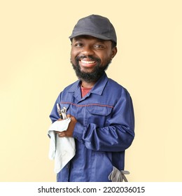 Funny African-American Car Mechanic With Big Head On Beige Background 