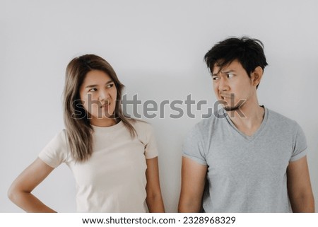 Funny angry face asian couple mad and fight at each other isolated on white.