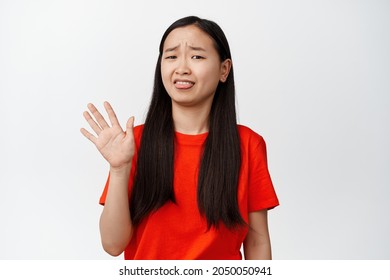 Funny Asian Girl Rejecting Something Disgusting, Shows Tongue And Wave Hand In Refusal, Dislike Smth, Show Cringe Expression, White Background