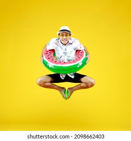 Funny Asian guy happy in vivid casual summer cloths and hat playing fancy watermelon donut float by jumping up high to enjoy swimming in outdoor water pool on joyful beach vacation of hot season. - Powered by Shutterstock