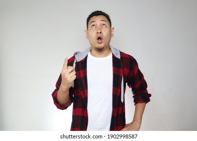 Funny Asian Man Pointing And Looking Up With Big Eyes And Mouth Open As He See Something From Above, Shocked Surprised Expression