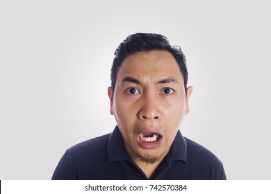 Funny Asian man shocked gesture silly face. Close up face portrait expression