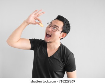 Funny Asian man showing how to eat cookies in a happy way.