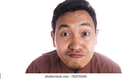 Funny Asian man smiling silly duck face. Close up face portrait expression isolated over white background