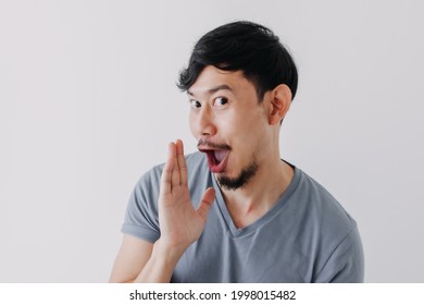 Funny Asian Man Is Whispering Some Secret Gossip Isolated On White Background.