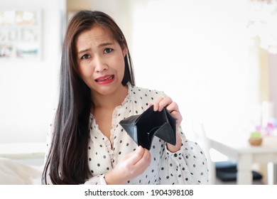 Funny Asian woman with empty wallet no more money. Young lady bankrupt unhappy sad or crying face.