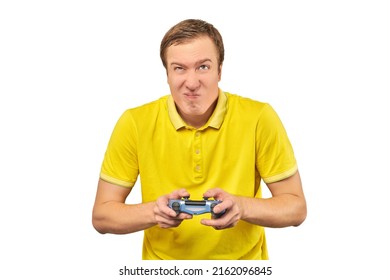 Funny attractive gamer in yellow T-shirt with gamepad isolated on white background. Cheerful young guy holding joy stick and playing videogames on TV, excited video game player