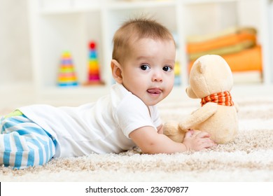 Funny Baby Boy Lying With Plush Toy Indoor