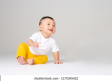 funny baby boy sitting on white background 