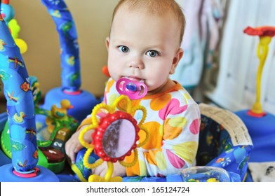 Funny Baby With Dummy In Baby Jumper 