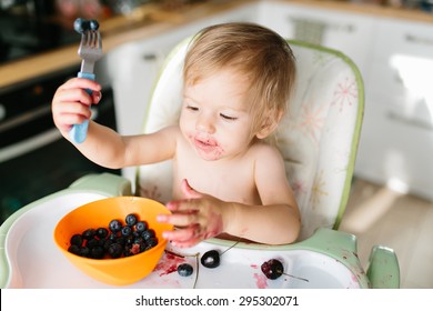 Funny Baby Eating Blueberries For The Breakfast. She Is Dirty With The Berries